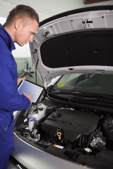 Mechanic testing the engine with a tablet computer